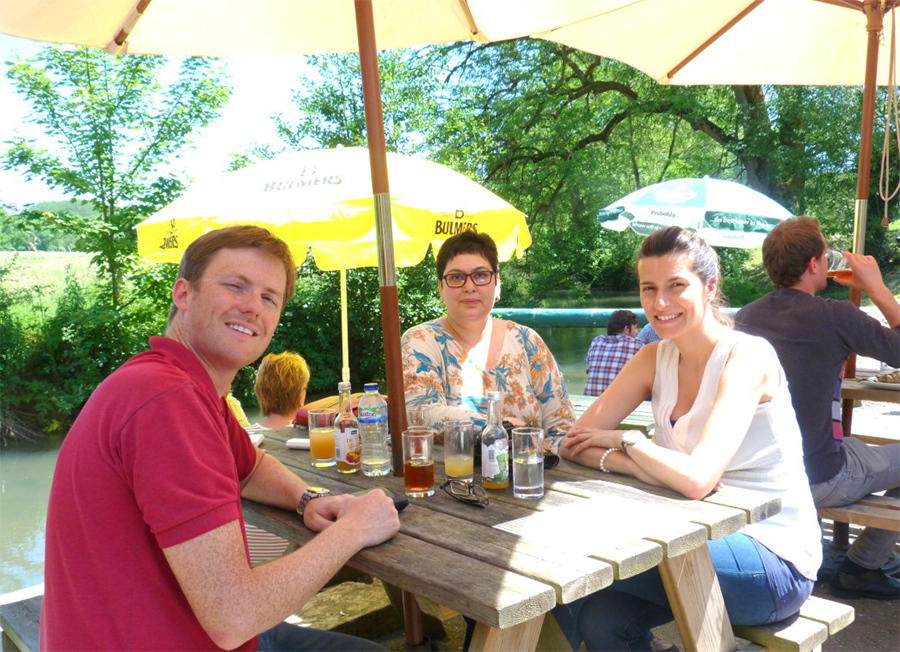 Guests enjoying lunch at a riverside pub during a private Cotswolds tour, relaxing outdoors as part of a bespoke guided experience
